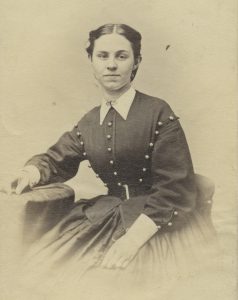 Photograph of a woman in a buttoned dress.