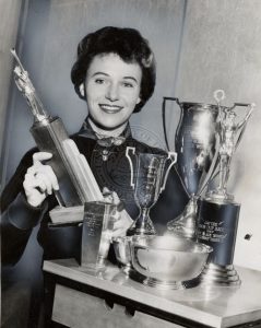 Woman posing with trophies