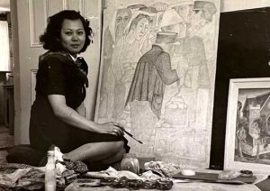 Japanese American woman posing next to her painting.