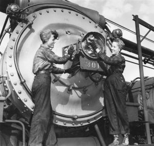 Two women working on a locomotive.